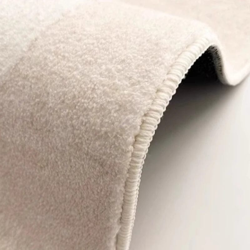 Tapis rond beige sur lit crème